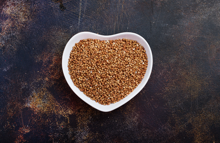 Plate with raw buckwheat on dark backgroundの写真素材