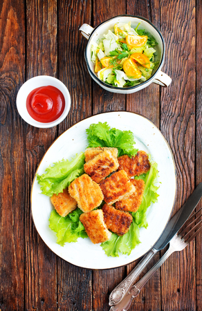 fish nuggets with latuk salad on plate, fried nuggetsの写真素材