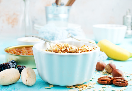 ingredients for helthy breakfast, raw oat flakes with banana and nutsの写真素材