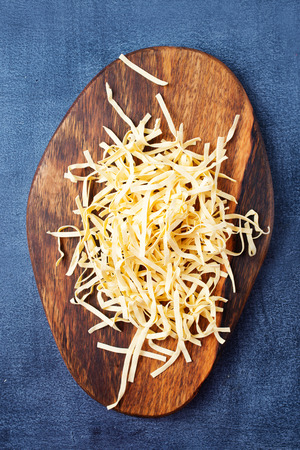 raw noodles on wooden board on a tableの写真素材