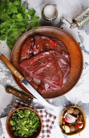 raw liver on plate on a tableの写真素材