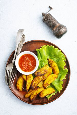 fried potato with tomato sauce, baked potatoの写真素材