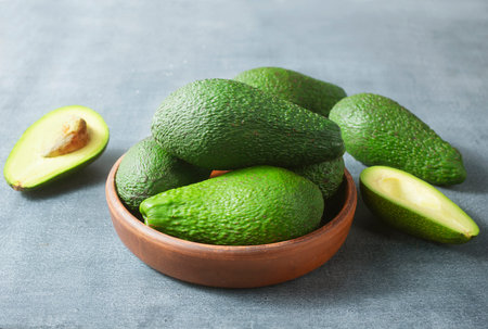 fresh avocado in brown bowl, green avocado