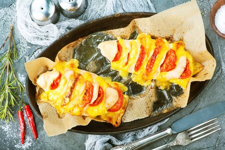 chicken breast with cheese and tomatoの写真素材