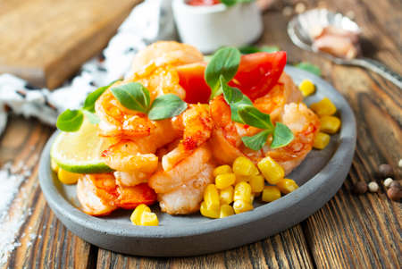fried shrimps with boiled corn, salad with shrimpsの写真素材