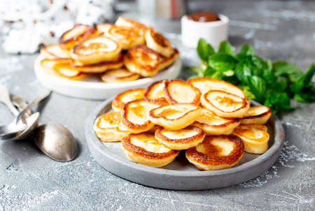 Mini pancakes on plate, top view table scene over a gray background.の写真素材