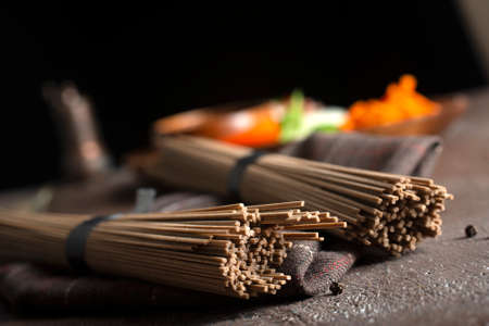 Uncooked soba and udon noodles. Traditional Japanese noodles on wooden table.の写真素材