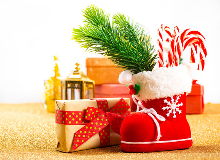 Christmas gift box and fir tree branch on gold background. View with copy spaceの写真素材