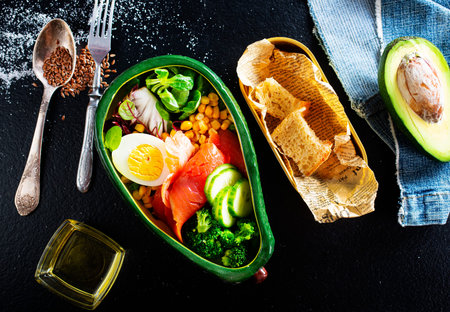 broccoli salnon and boiled egg in ceramic bowl served with corn and seeds