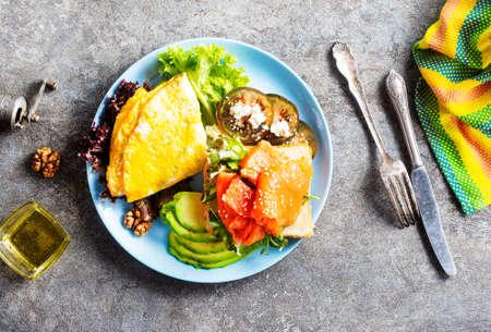 omelette with salmon and fresh avocado on plateの写真素材