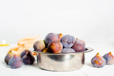 A few figs in a bowl on a light background.