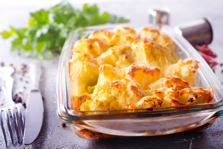 Savory food: baked cauliflower with cheese, eggs and cream close-up in a baking dishの写真素材