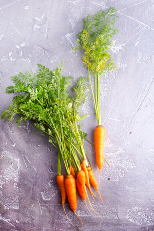 Bunch of fresh carrots with green leaves over wooden background. vegetable.の写真素材