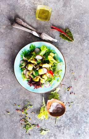 Avocado salad with cucumber and other vegetables on a plateの写真素材
