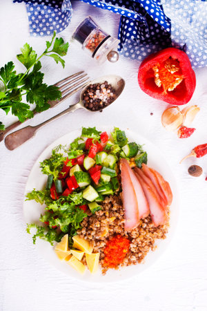 A plate of buckwheat with meat, salad, cheese on white backgrondの写真素材