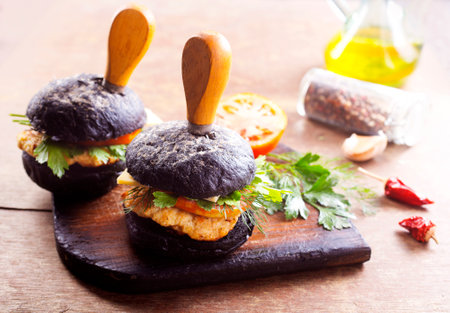 Tasty craft burger with black bun on the boardの写真素材