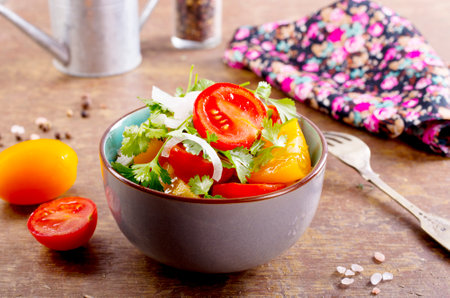 fresh tomato salad on plate and on a tableの写真素材