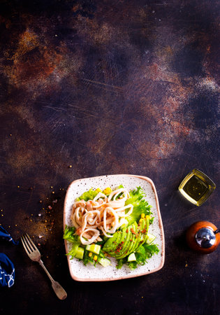 Salad with squid and avocado on white plateの写真素材