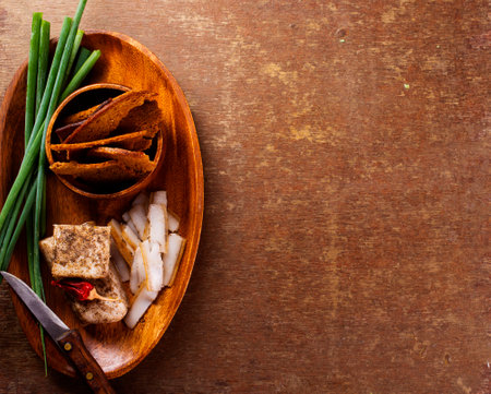 Pork fatback with spices, rye bread and green onion on wooden tableの写真素材