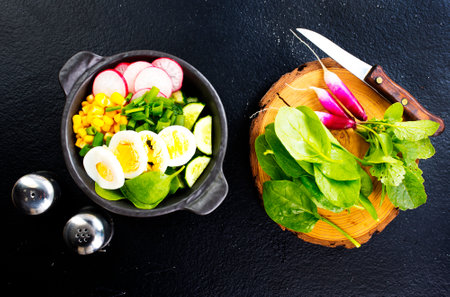 Bowl of vegetarian salad with boiled eggs- radishes- cucumbers- corn saladの写真素材