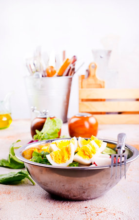 Bowl of vegetarian salad with boiled eggs- radishes- cucumbers- corn saladの写真素材