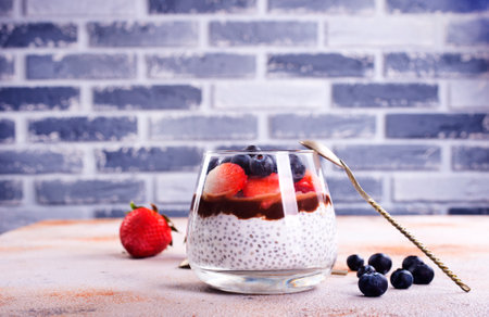 Healthy breakfast, desert, with chia seed pudding, cream, raspberry jam and fresh berriesの写真素材
