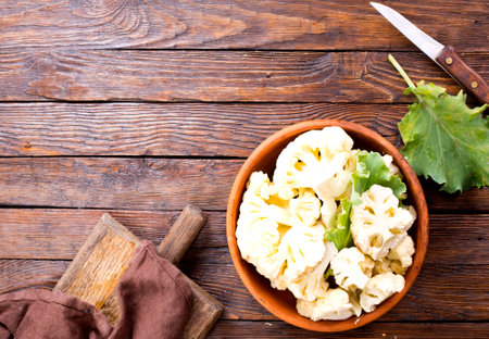 Fresh organic cauliflower cut into small pieces in ceramic bowlの写真素材