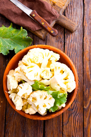 Fresh organic cauliflower cut into small pieces in ceramic bowlの写真素材