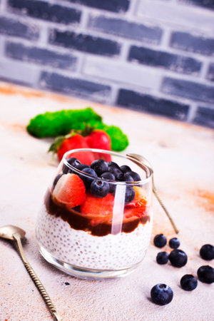 Healthy breakfast, desert, with chia seed pudding, cream, raspberry jam and fresh berriesの写真素材