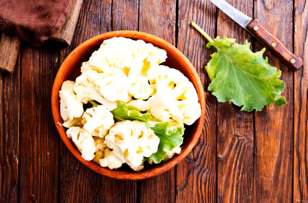 Fresh organic cauliflower cut into small pieces in ceramic bowlの写真素材