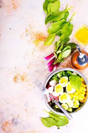 Bowl of vegetarian salad with boiled eggs- radishes- cucumbers- corn saladの写真素材
