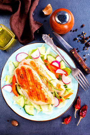 Marinated grilled healthy chicken breasts cooked on a summer BBQ and served with fresh herbs and lemon juice on plateの写真素材