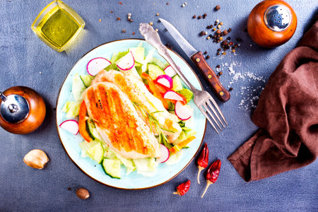 Marinated grilled healthy chicken breasts cooked on a summer BBQ and served with fresh herbs and lemon juice on plateの写真素材