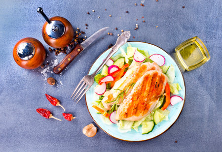 Marinated grilled healthy chicken breasts cooked on a summer BBQ and served with fresh herbs and lemon juice on plateの写真素材