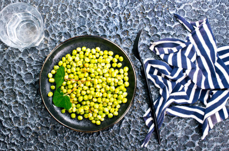 Green peas in the black bowlの写真素材