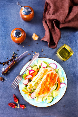 Marinated grilled healthy chicken breasts cooked on a summer BBQ and served with fresh herbs and lemon juice on plateの写真素材