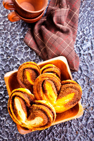 Freshly baked cinnamon rolls in wooden bowlの写真素材