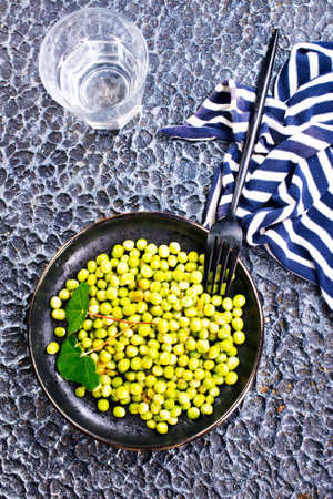 Green peas in the black bowlの写真素材