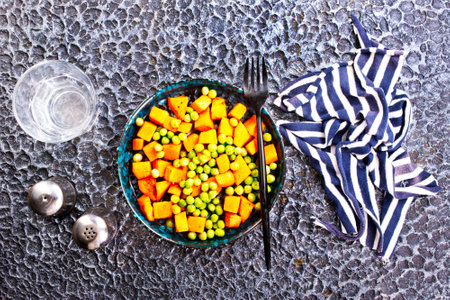 Peas and carrots in a black salad bowlの写真素材