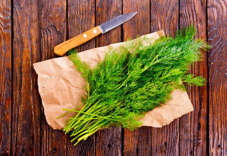 Chopped fresh dill on a cutting Board and a bunch of dill preparation for freezing serving size organic healthy thing natural product portion on a wooden table. Top view,の写真素材
