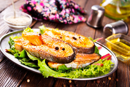 Fried salmon steak with spice vegetables on wooden tableの写真素材