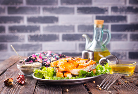 Fried salmon steak with spice vegetables on wooden tableの写真素材