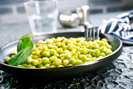 Green peas in the black bowlの写真素材