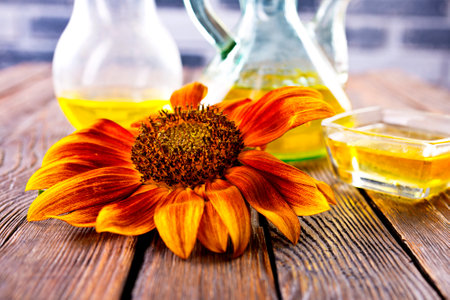 Organic sunflower oil in a small glass jar with sunflower seeds and fresh flowers. Outdoorsの写真素材