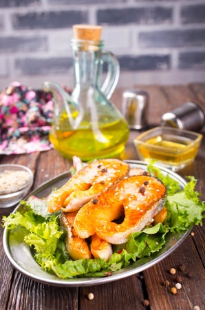 Fried salmon steak with spice vegetables on wooden tableの写真素材