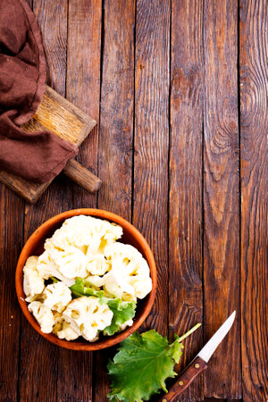 Fresh organic cauliflower cut into small pieces in ceramic bowlの写真素材