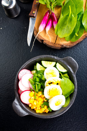 Bowl of vegetarian salad with boiled eggs- radishes- cucumbers- corn saladの写真素材