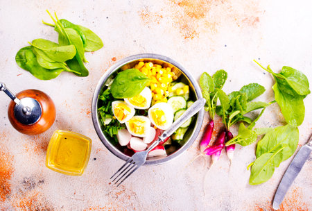 Bowl of vegetarian salad with boiled eggs- radishes- cucumbers- corn saladの写真素材