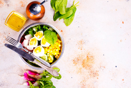Bowl of vegetarian salad with boiled eggs- radishes- cucumbers- corn saladの写真素材