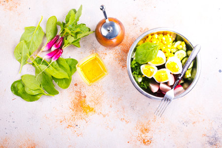 Bowl of vegetarian salad with boiled eggs- radishes- cucumbers- corn saladの写真素材